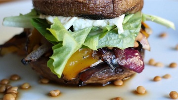 image of a tasty looking portobello and grilled veggie burger served with goats cheese