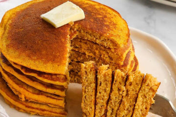 close up image of a stack of perfect pumpkin pancakes topped with butter 