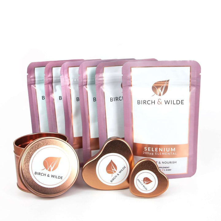 product pack shot of the front of 6 pouches of Birch & Wilde Elemental selenium capsules in a refill pouch with a plain background and rose gold capsule refill tins alongside