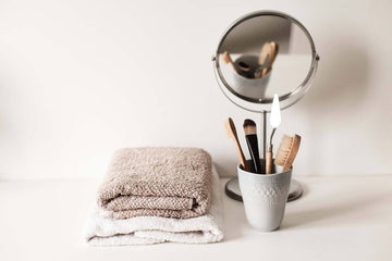 discover the top 7 beauty tips and hacks for busy people with birch and wilde. Image of beauty items against plain beige background including make-up brushes mirror and towels