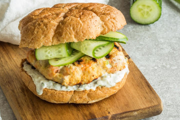 A Barbequed Salmon burger served in a seeded bun with caper aioli and fresh cucumber