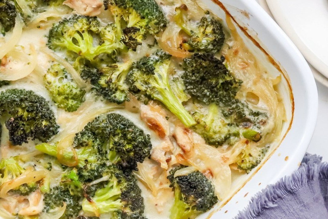 Image from above of simple chicken and broccoli casserole with bright green broccoli florets and tender chicken breast strips in a white casserole dish