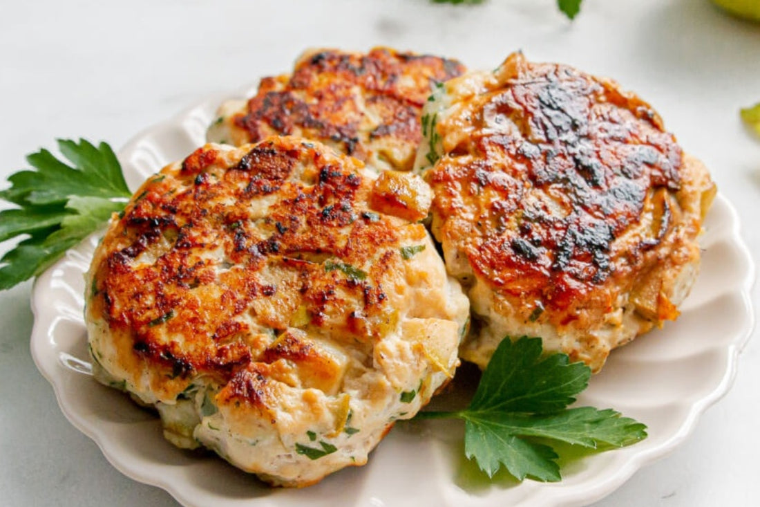 Three pair and chicken sausage patties presented together sitting on green herbs and on a white plate