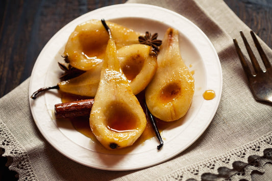Pears Poached in Vanilla & Cinnamon served with star annis and in a white ceramic bowl