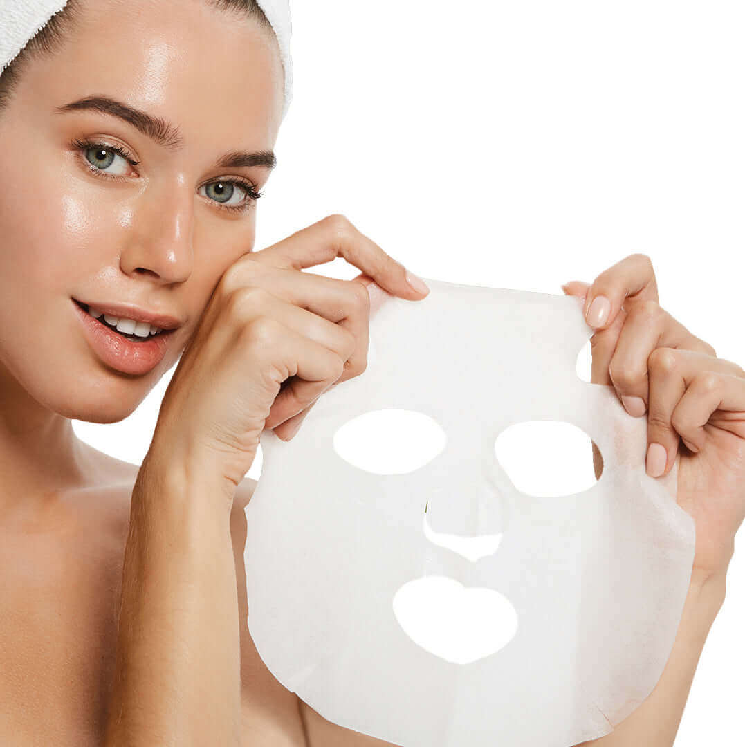 head shot of woman holding up a facial sheet mask with both her hands to show eye and mouth holes