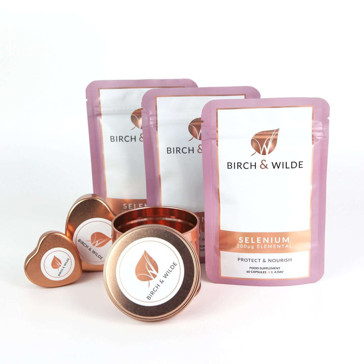 product pack shot of the front of 3 pouches of Birch & Wilde Elemental selenium capsules in a refill pouch with a plain background and rose gold capsule refill tins alongside
